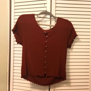 Burgundy shirt with ruffled detailing.